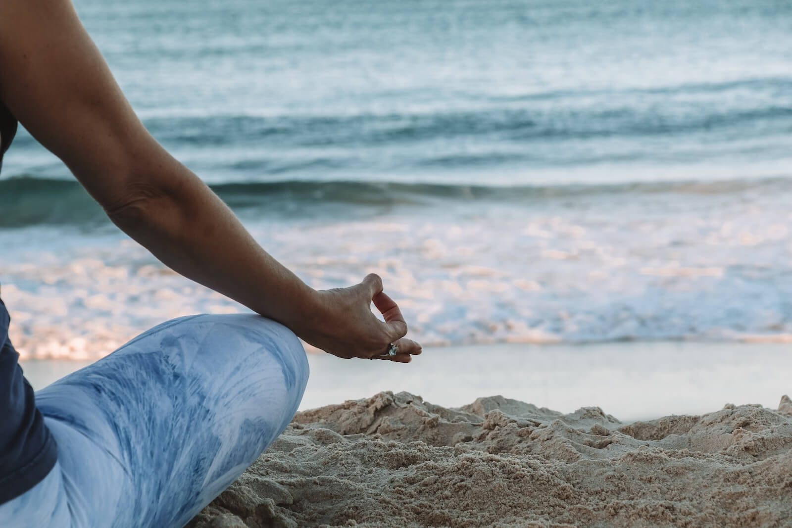 person sitting on beach practicing karma yoga