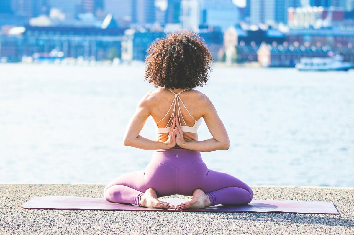 woman doing yoga facing river