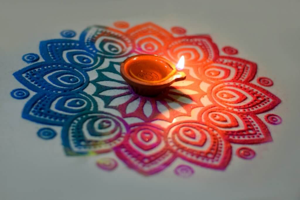 lit candle on rangoli design